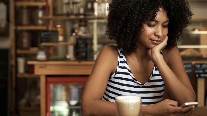 Mujer sosteniendo un teléfono, estafas en línea